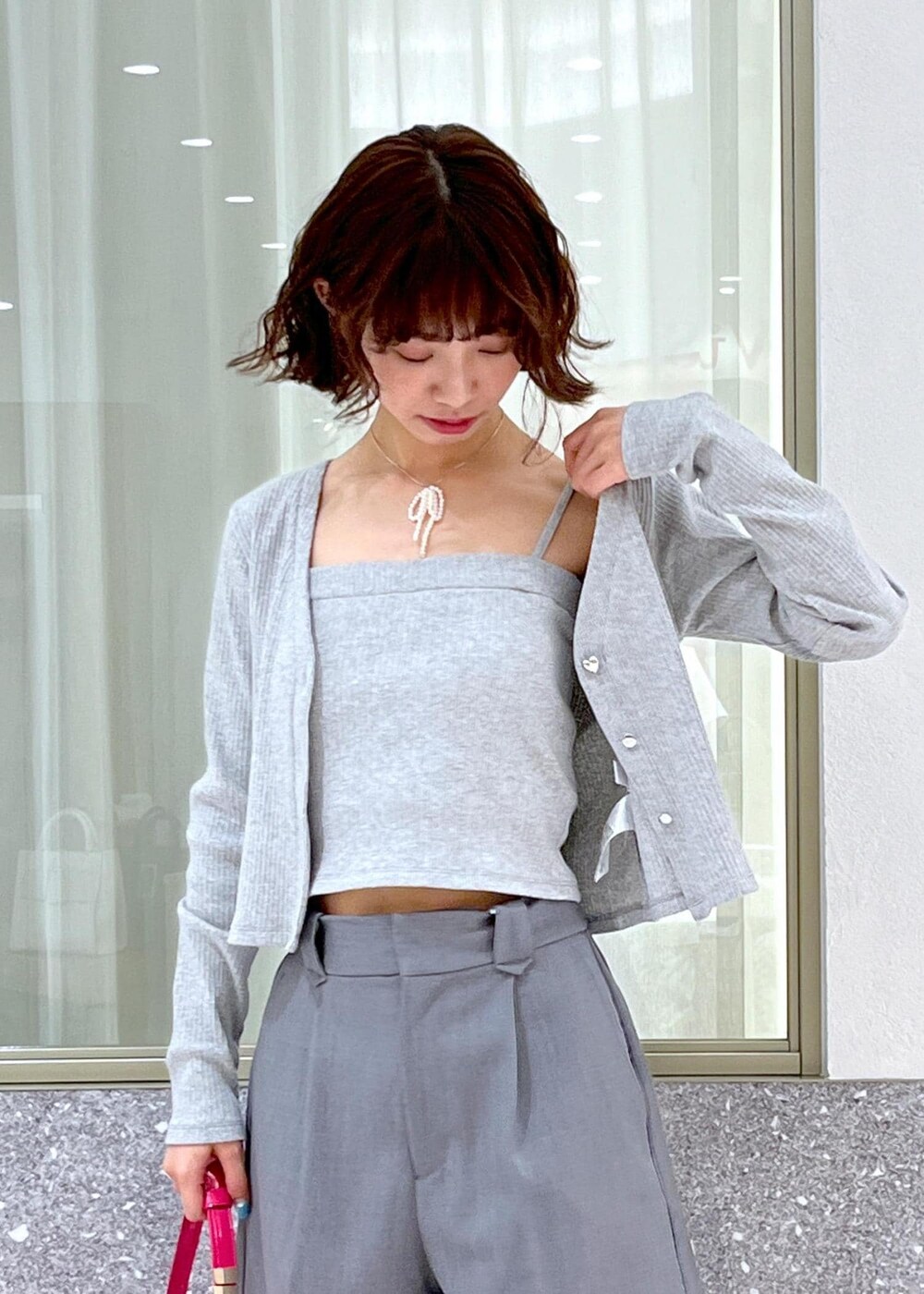 ブラック系のサンダル、ピンク系のハンドバッグ、グレー系のその他パンツを着用したレディースの春コーディネートの5枚目の写真