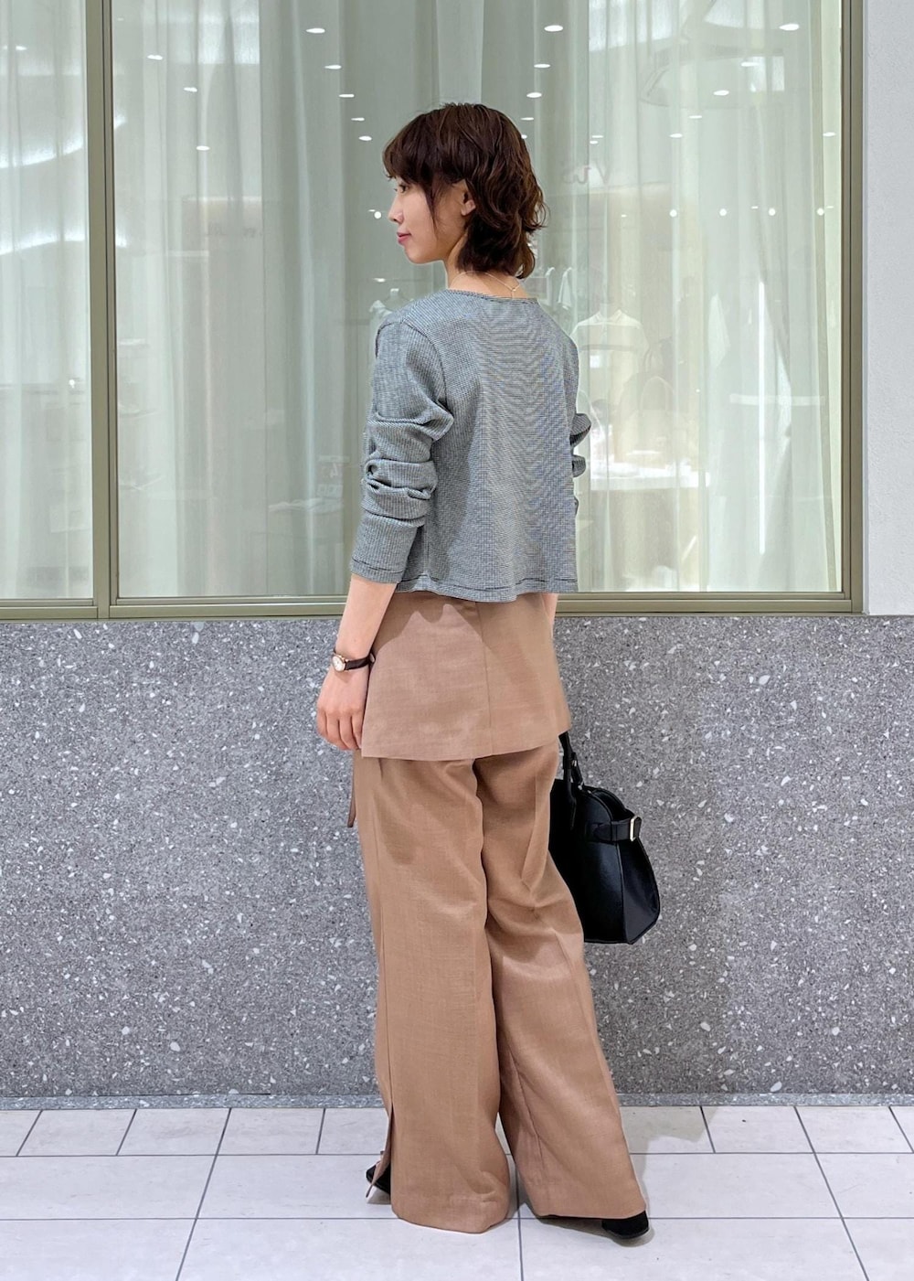 ブラック系のサンダル、ブラウン系のスラックス、ブラック系のトートバッグを着用したレディースの夏コーディネートの4枚目の写真