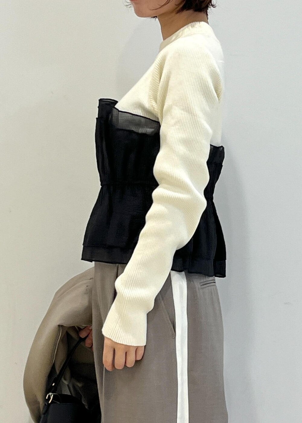 ブラック系のパンプス、ホワイト系のニット/セーター、ベージュ系のテーラードジャケットを着用したレディースの冬コーディネートの7枚目の写真
