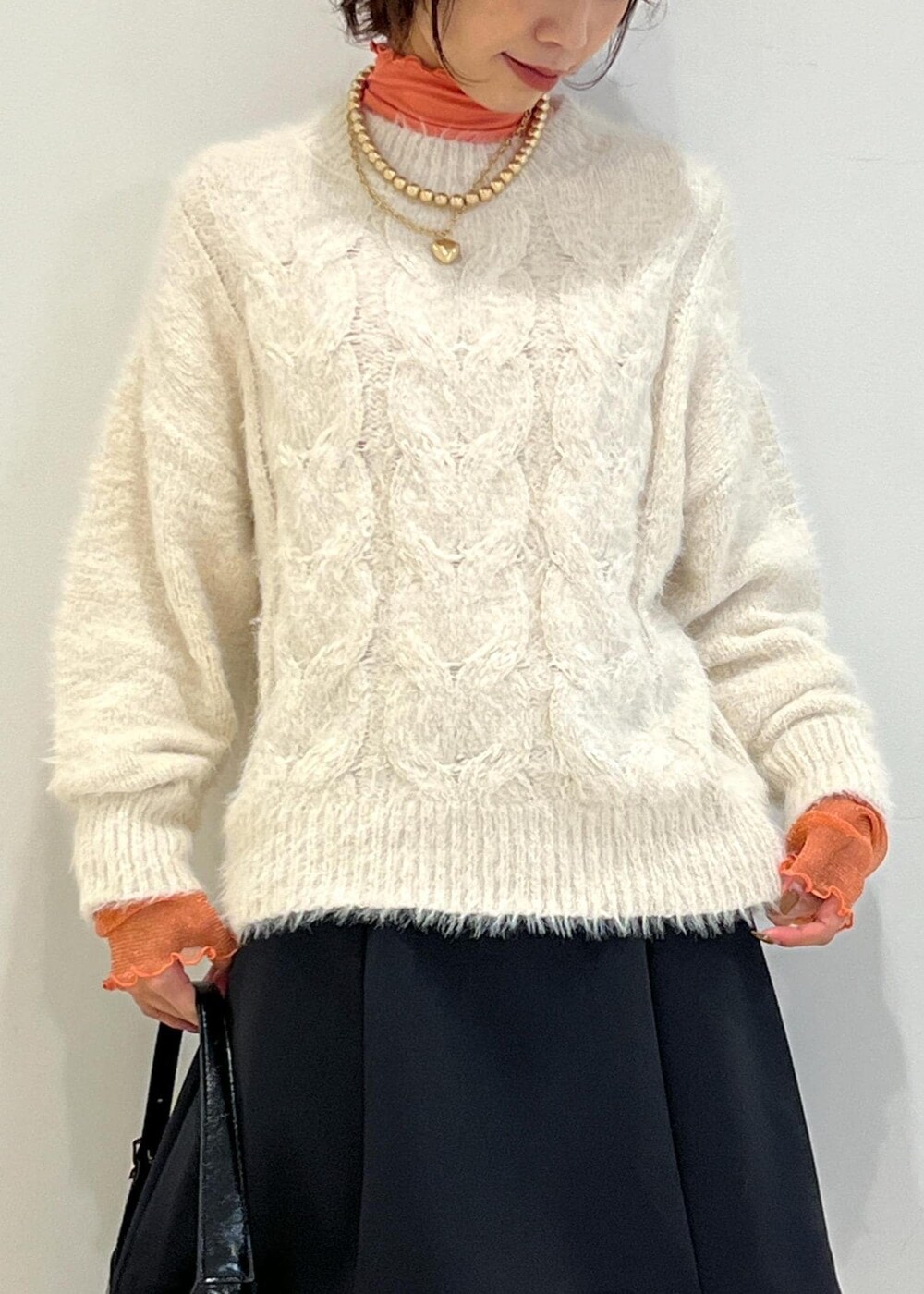 ブラック系のブーツ、ブラック系のハンドバッグ、ブラック系のスカートを着用したレディースの冬コーディネートの6枚目の写真