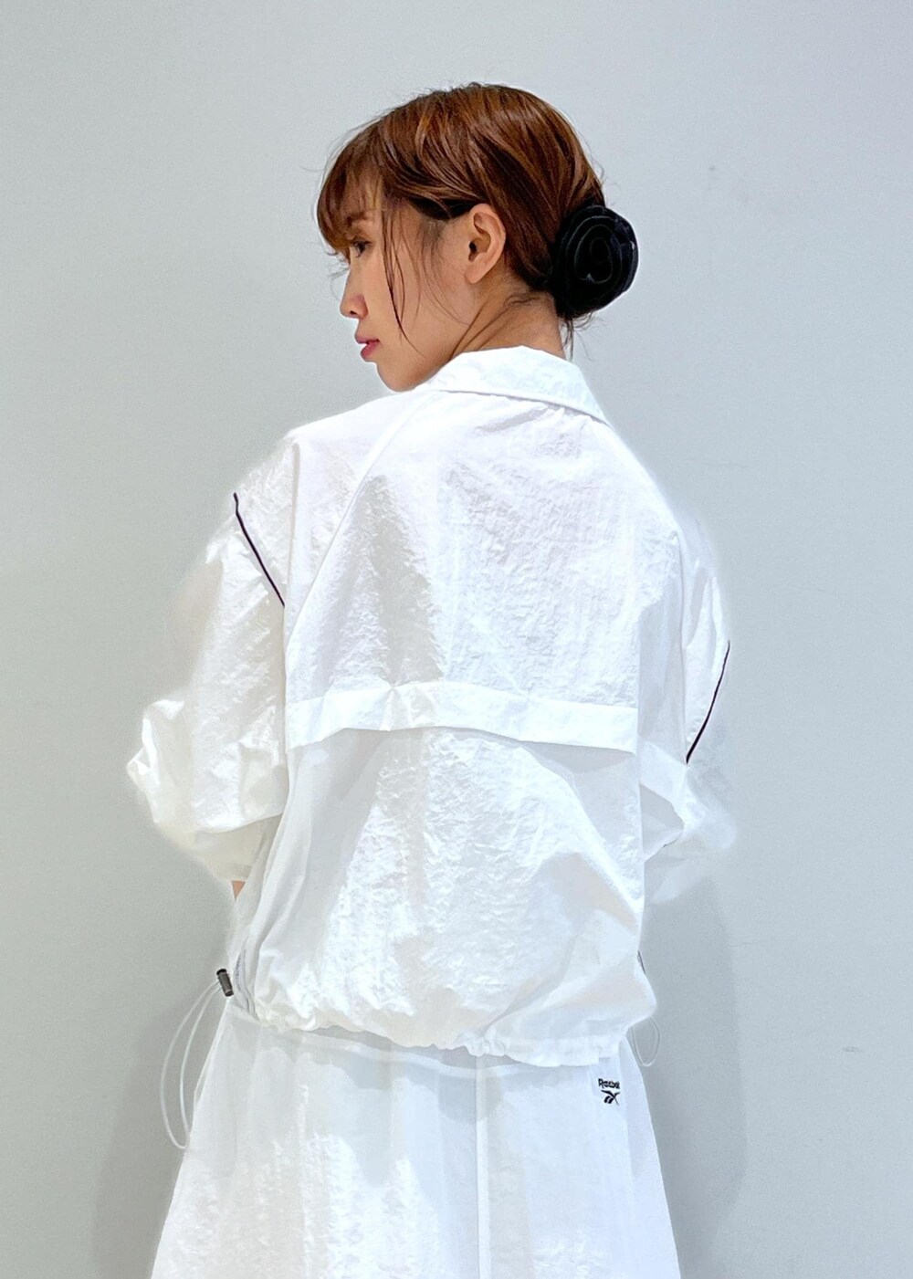 ブラック系のパンプス、ホワイト系のスカート、ベージュ系のキャミソールを着用したレディースの春コーディネートの7枚目の写真