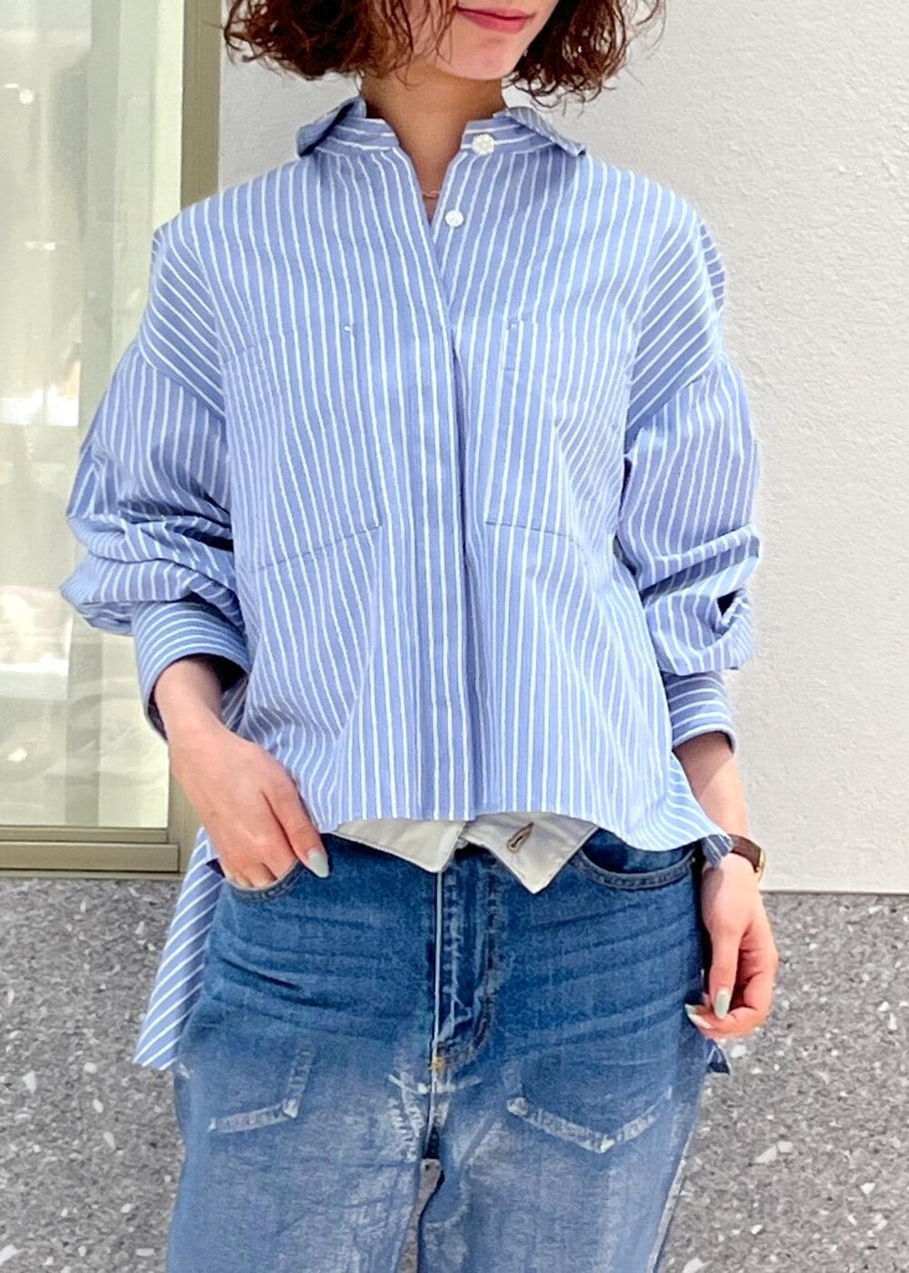 ブルー系のデニムパンツ、ブルー系のシャツ/ブラウス、ホワイト系のボストンバッグを着用したレディースの春コーディネートの5枚目の写真