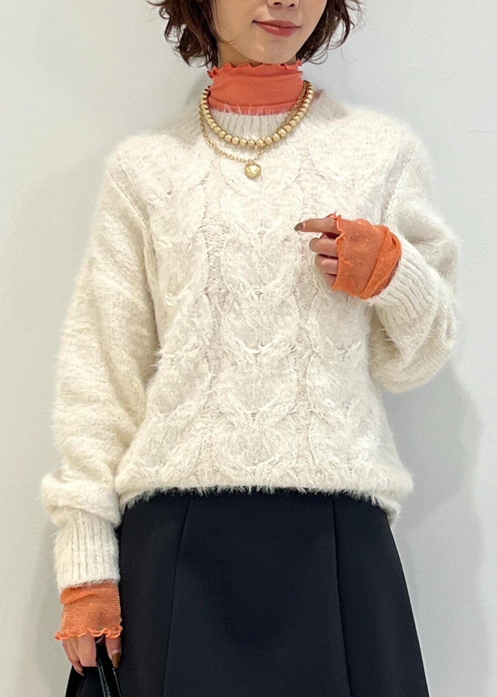 ブラック系のブーツ、ブラック系のハンドバッグ、ブラック系のスカートを着用したレディースの冬コーディネートの5枚目の写真