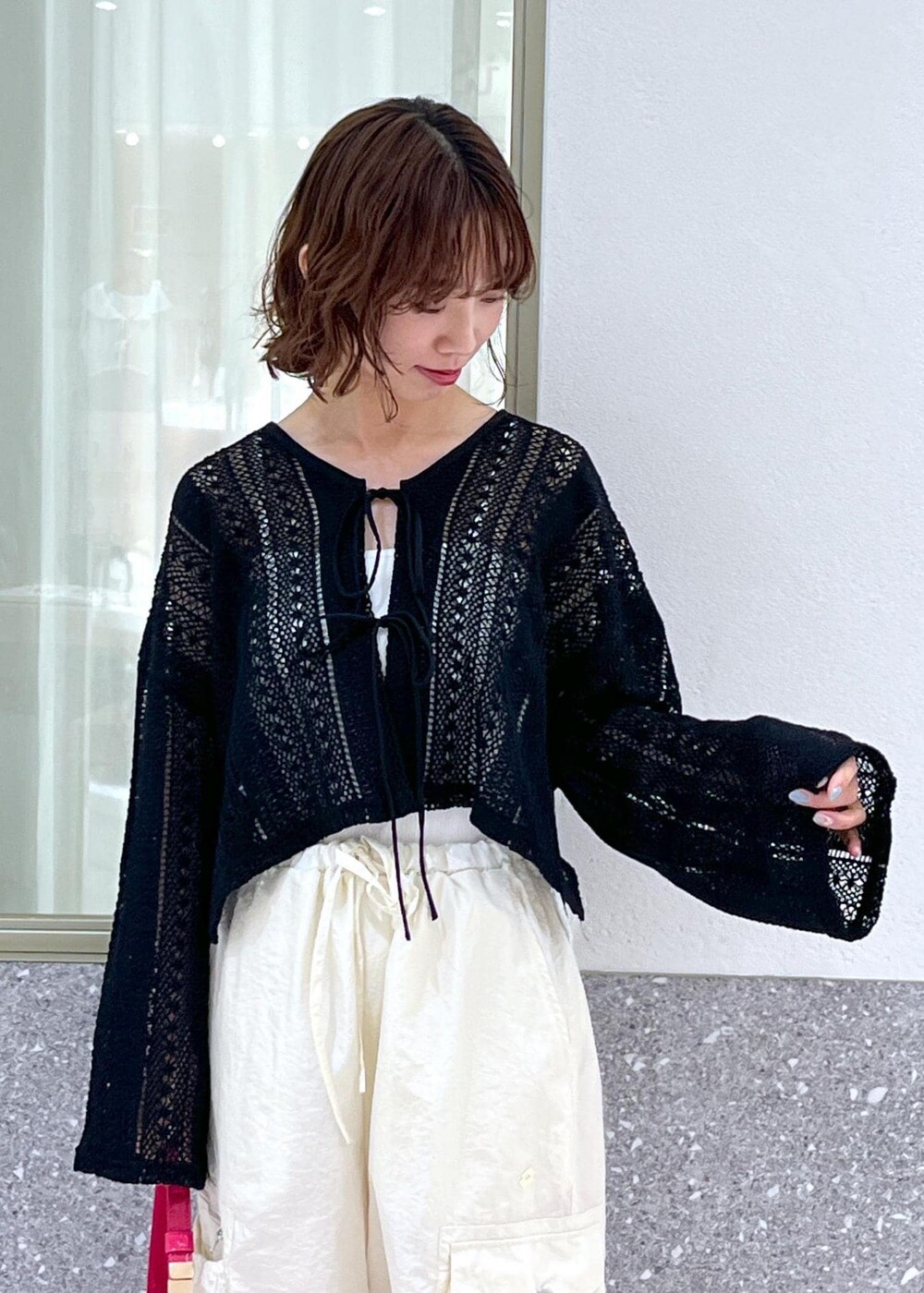 ブラック系のサンダル、ピンク系のハンドバッグ、ブラック系のカーディガン/ボレロを着用したレディースの夏コーディネートの3枚目の写真