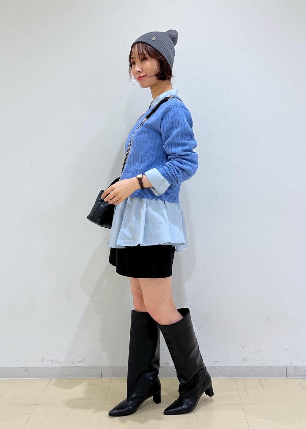 ブラック系のブーツ、ブルー系のシャツ/ブラウス、ブルー系のニット/セーターを着用したレディースの冬コーディネートの2枚目の写真