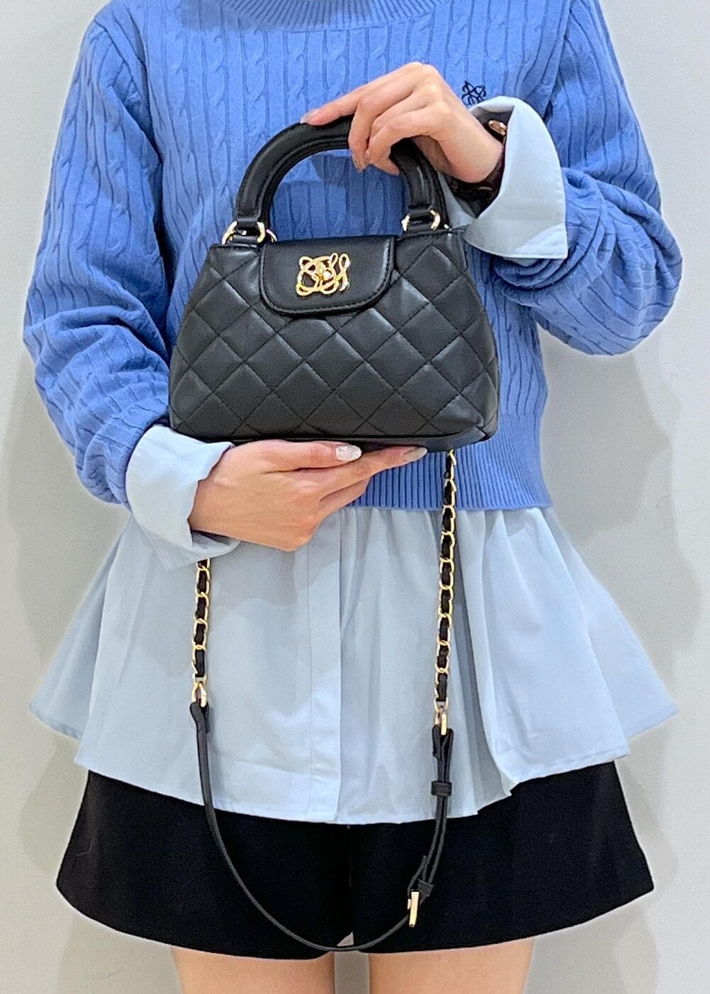 ブラック系のブーツ、ブルー系のシャツ/ブラウス、ブルー系のニット/セーターを着用したレディースの冬コーディネートの9枚目の写真