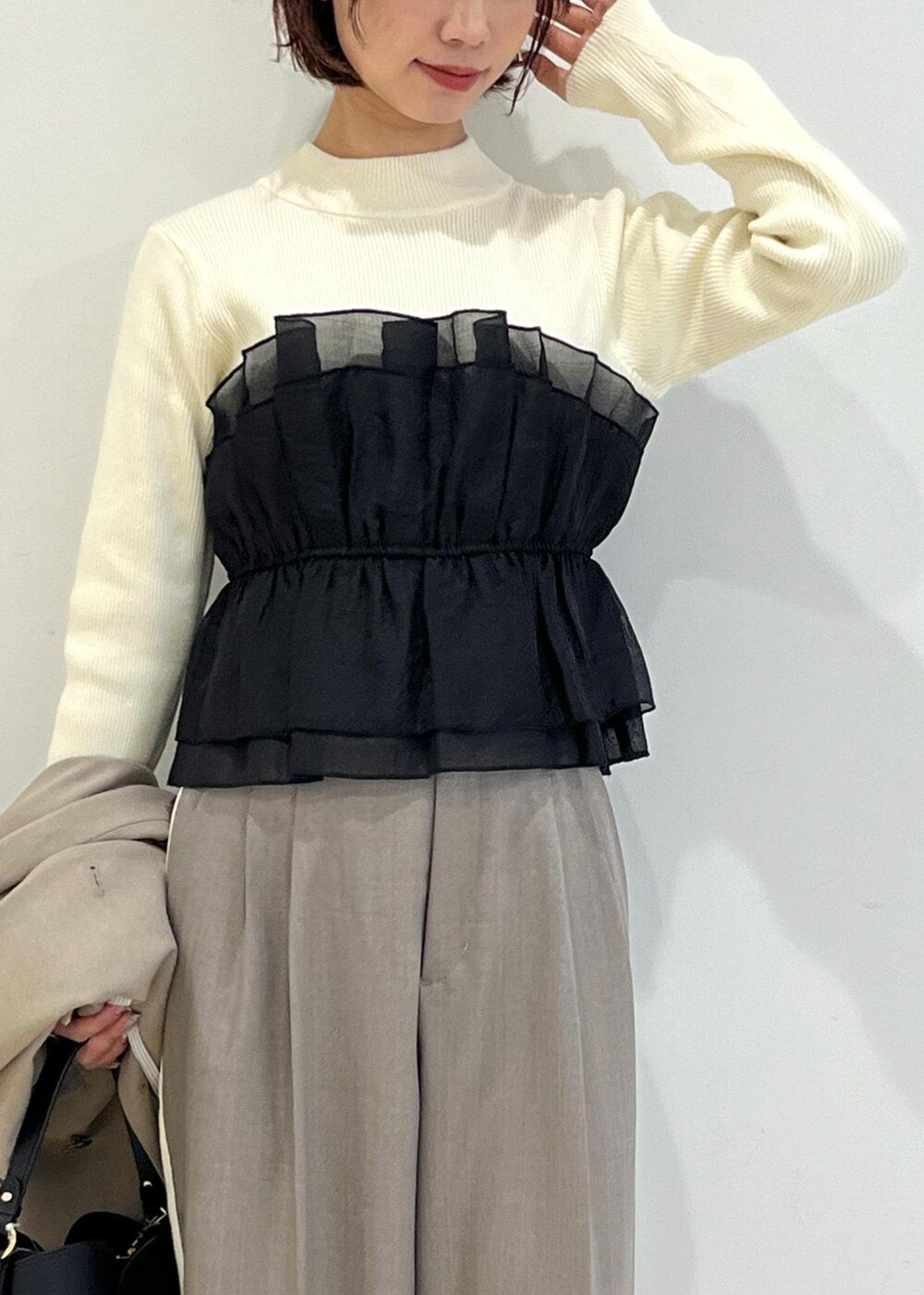 ブラック系のパンプス、ホワイト系のニット/セーター、ベージュ系のテーラードジャケットを着用したレディースの冬コーディネートの6枚目の写真