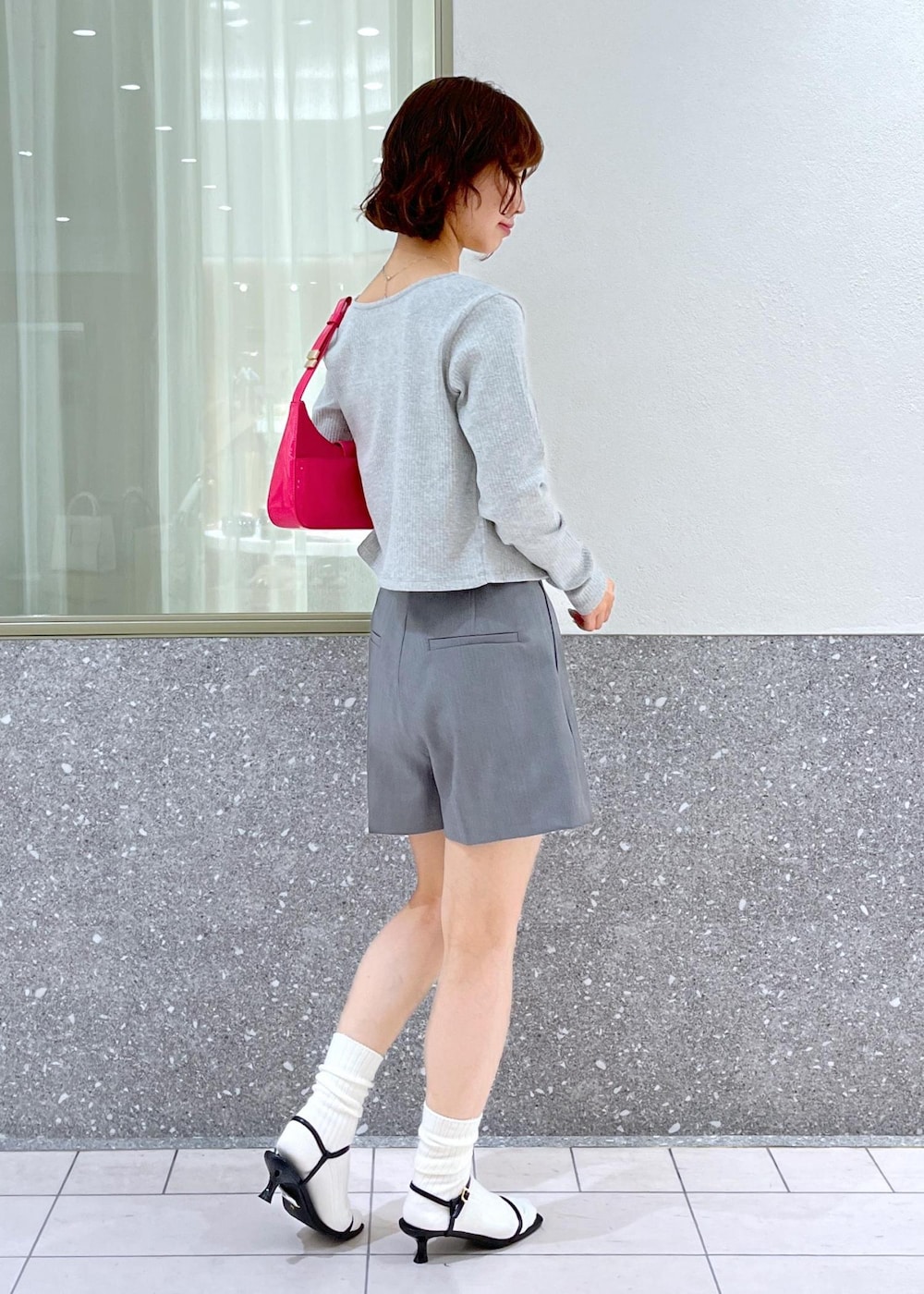 ブラック系のサンダル、ピンク系のハンドバッグ、グレー系のその他パンツを着用したレディースの春コーディネートの3枚目の写真