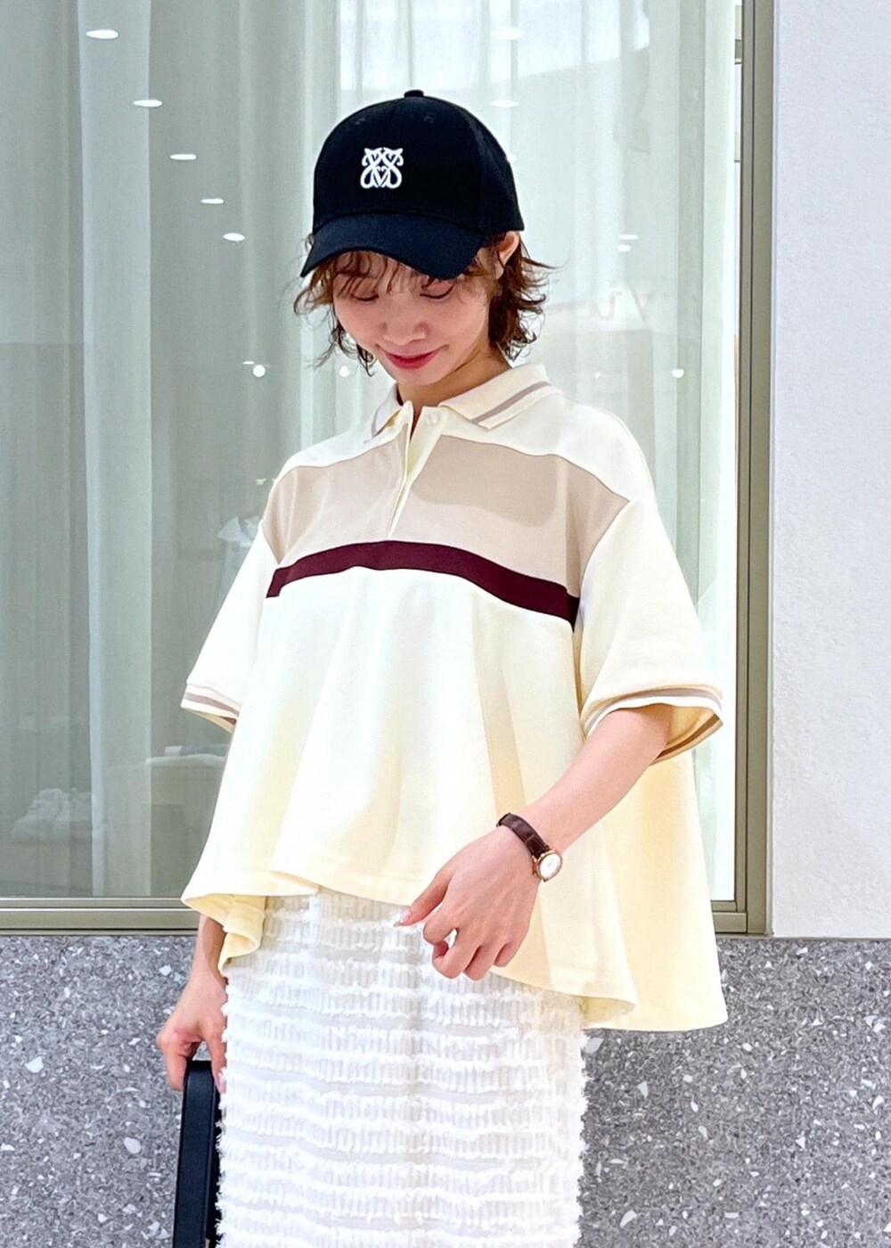 ブラック系のサンダル、ホワイト系のスカート、ベージュ系のポロシャツを着用したレディースの夏コーディネートの8枚目の写真