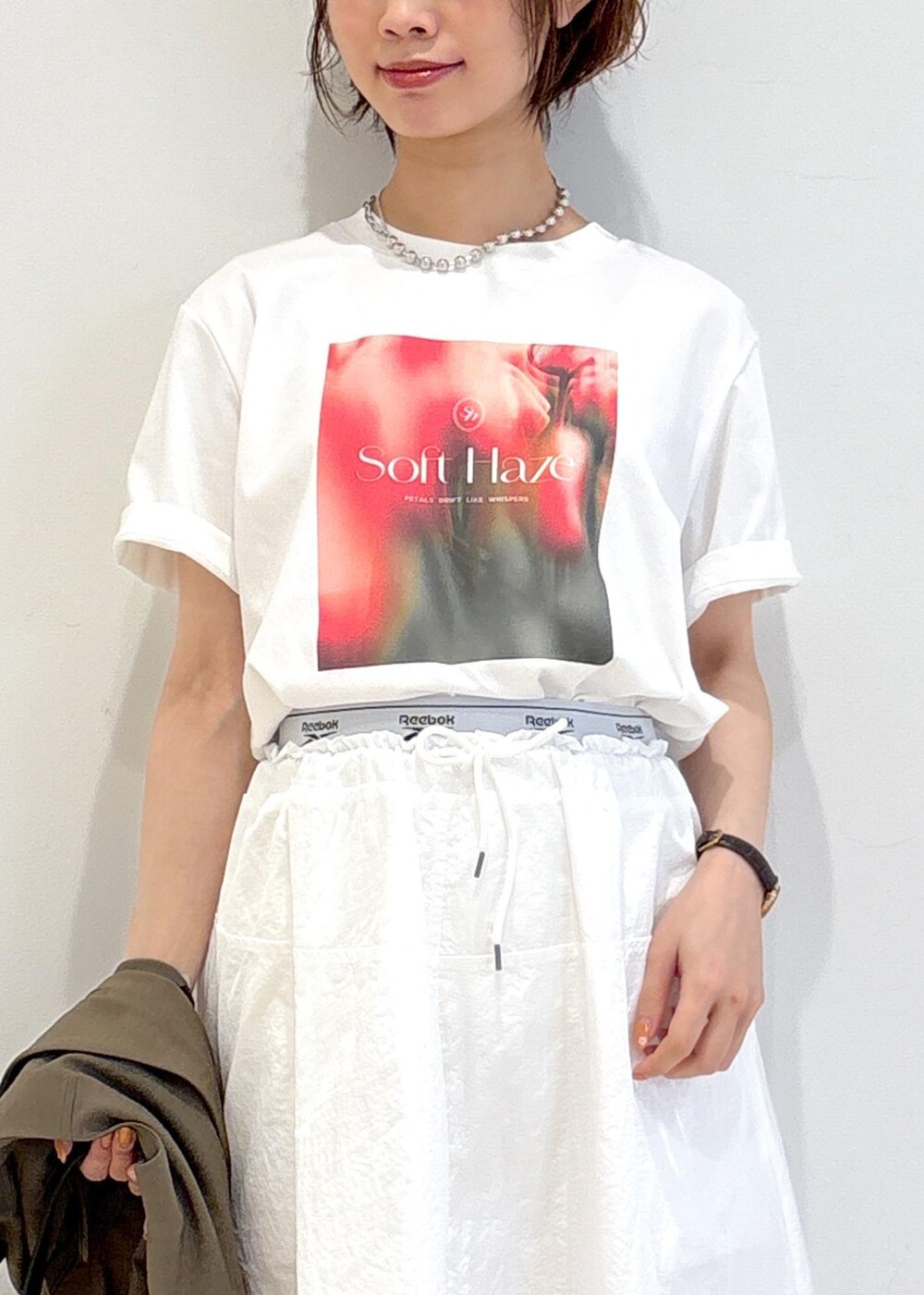 ブラック系のショルダーバッグ、ブラック系のバレエシューズ、ホワイト系のTシャツ/カットソーを着用したレディースの春コーディネートの8枚目の写真
