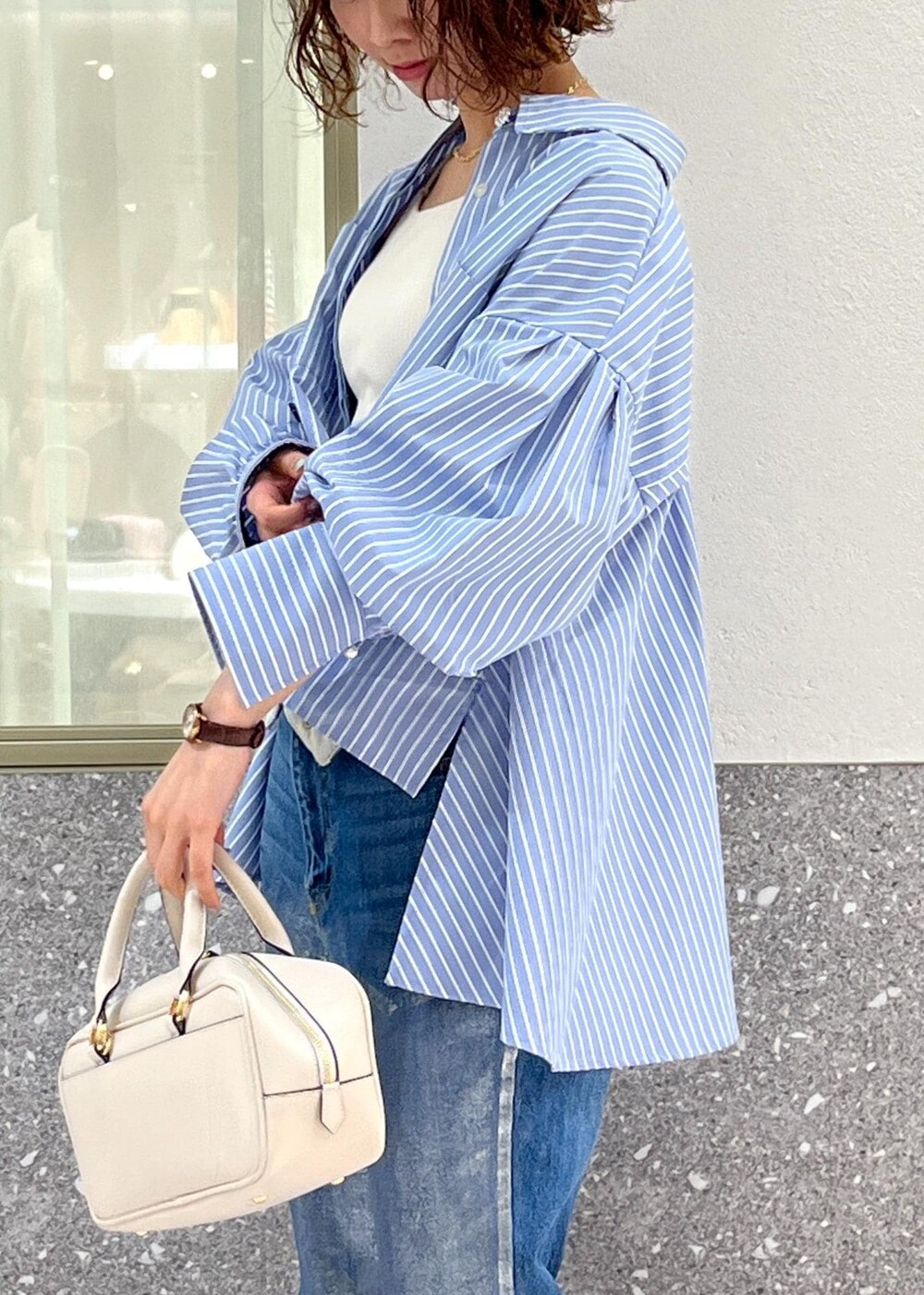 ブルー系のデニムパンツ、ブルー系のシャツ/ブラウス、ホワイト系のボストンバッグを着用したレディースの春コーディネートの4枚目の写真