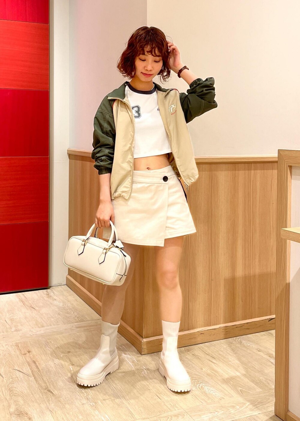 ホワイト系のブーツ、ホワイト系のボストンバッグ、ベージュ系のスラックスを着用したレディースの冬コーディネートの2枚目の写真