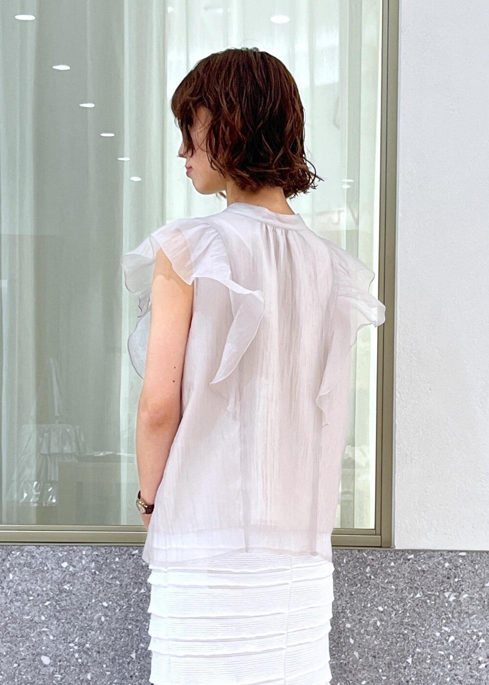 ブラック系のサンダル、ホワイト系のスカート、ホワイト系のキャミソールを着用したレディースの春コーディネートの5枚目の写真