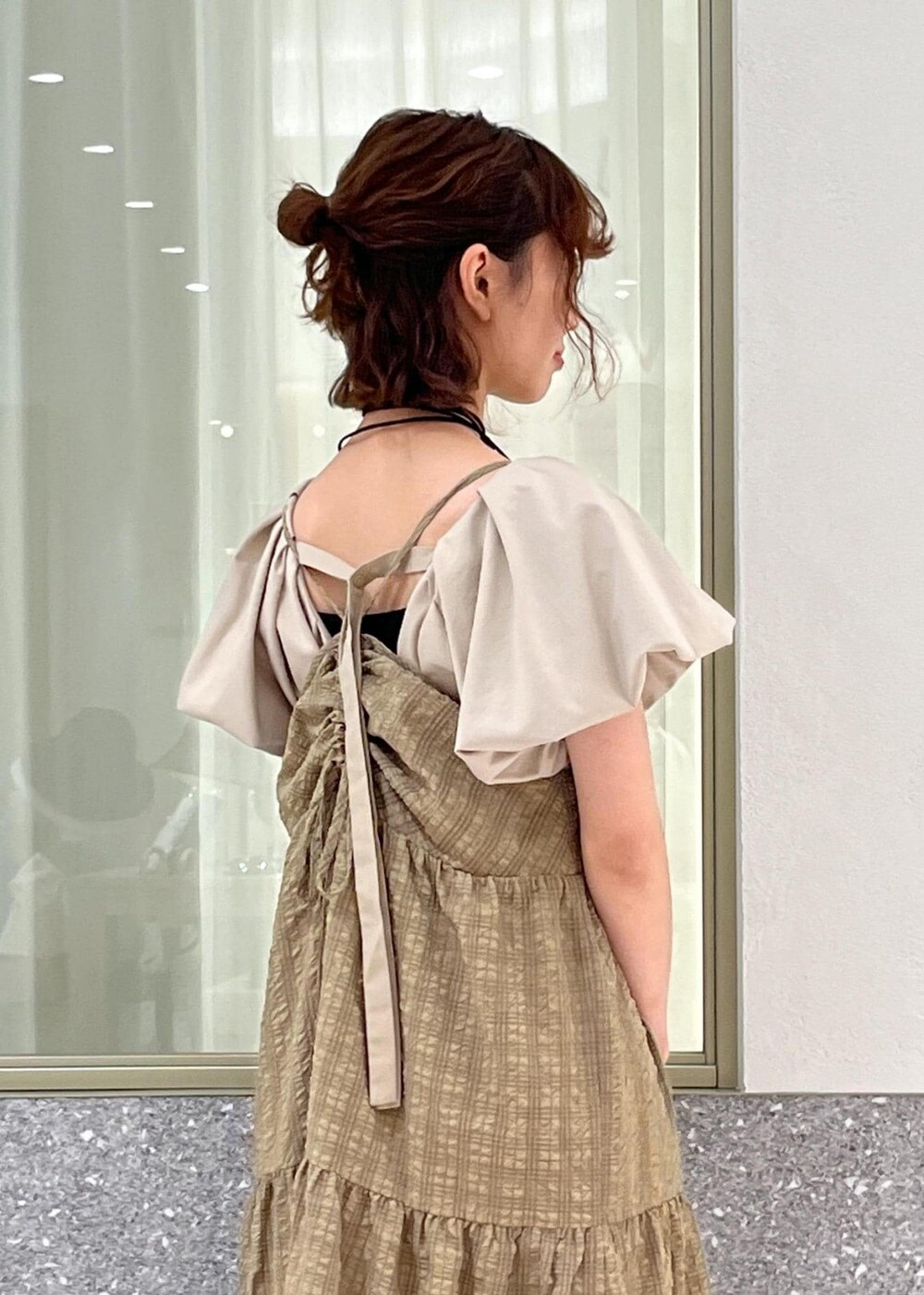 ブラック系のサンダル、ベージュ系のTシャツ/カットソー、ブラウン系のワンピースを着用したレディースの春コーディネートの5枚目の写真