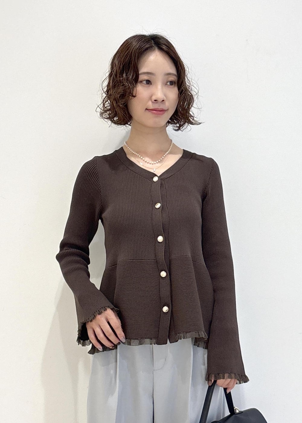 ブラック系のハンドバッグ、ブルー系のその他パンツ、ブラック系のパンプスを着用したレディースの秋コーディネートの6枚目の写真