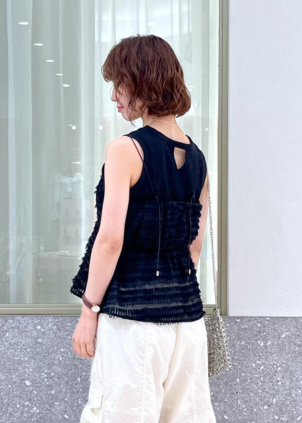 シルバー系のショルダーバッグ、ホワイト系のサンダル、ブラック系のタンクトップを着用したレディースの夏コーディネートの5枚目の写真