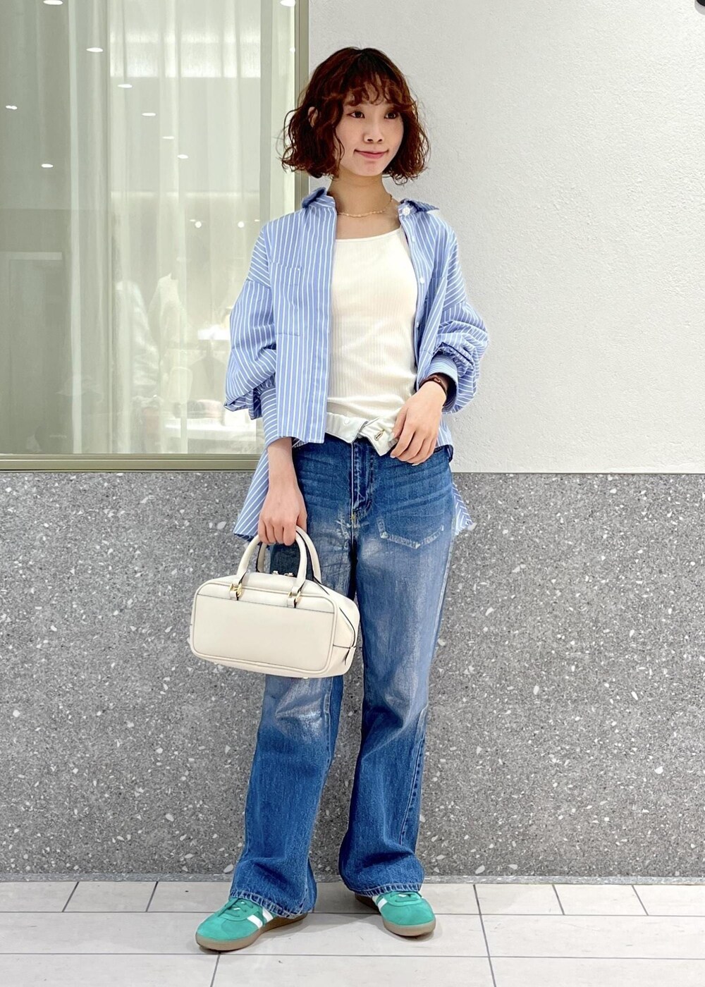 ブルー系のデニムパンツ、ブルー系のシャツ/ブラウス、ホワイト系のボストンバッグを着用したレディースの春コーディネートの2枚目の写真