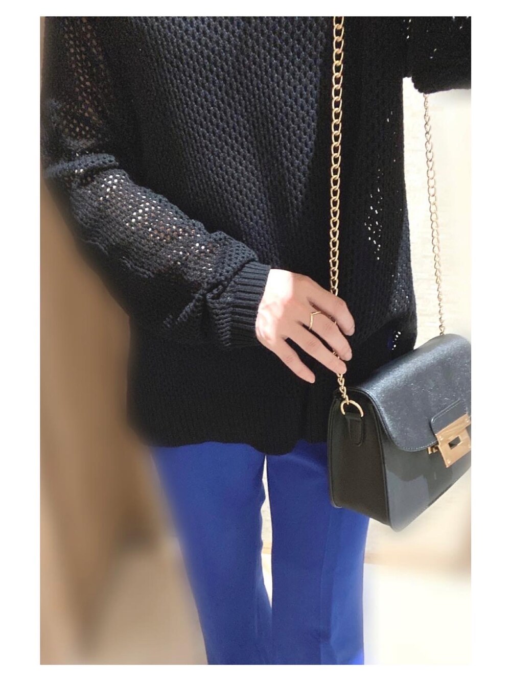 ブラック系のトップス、ブルー系のスラックス、ゴールド系のリングを着用したレディースの夏コーディネートの2枚目の写真