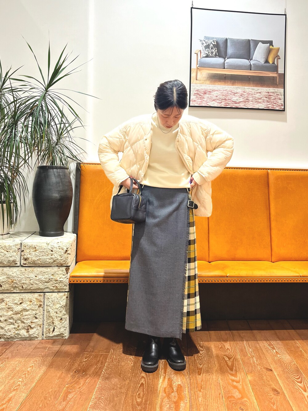 ブラック系のボストンバッグ、ホワイト系のダウンジャケット/コート、ホワイト系のニット/セーターを着用したレディースの冬コーディネートの3枚目の写真