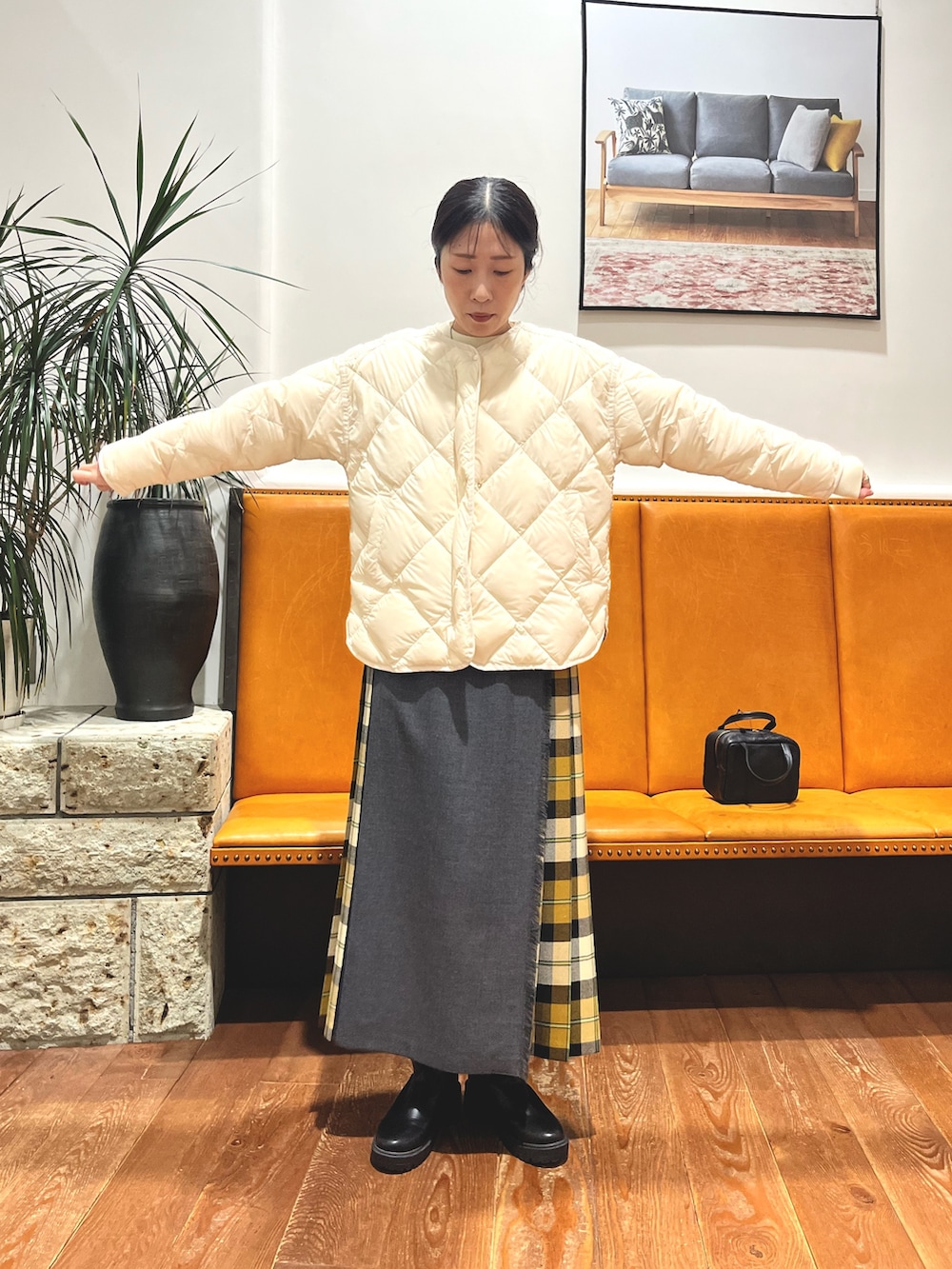 ブラック系のボストンバッグ、ホワイト系のダウンジャケット/コート、ホワイト系のニット/セーターを着用したレディースの冬コーディネートの7枚目の写真