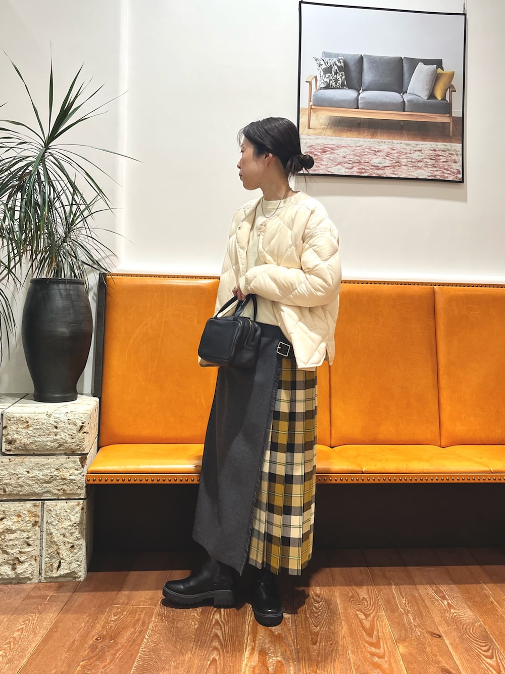 ブラック系のボストンバッグ、ホワイト系のダウンジャケット/コート、ホワイト系のニット/セーターを着用したレディースの冬コーディネートの2枚目の写真