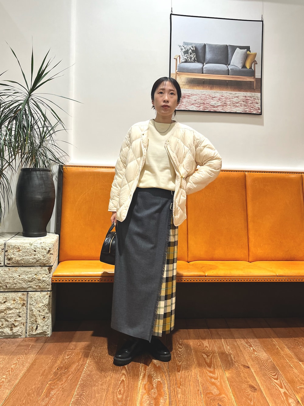 ブラック系のボストンバッグ、ホワイト系のダウンジャケット/コート、ホワイト系のニット/セーターを着用したレディースの冬コーディネートの5枚目の写真