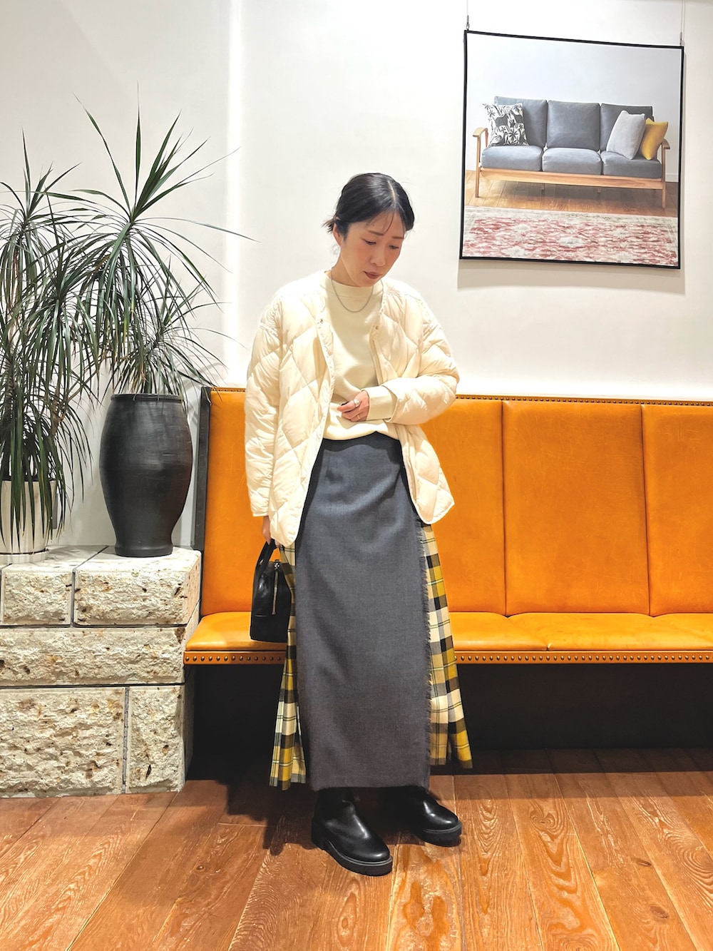 ブラック系のボストンバッグ、ホワイト系のダウンジャケット/コート、ホワイト系のニット/セーターを着用したレディースの冬コーディネートの6枚目の写真