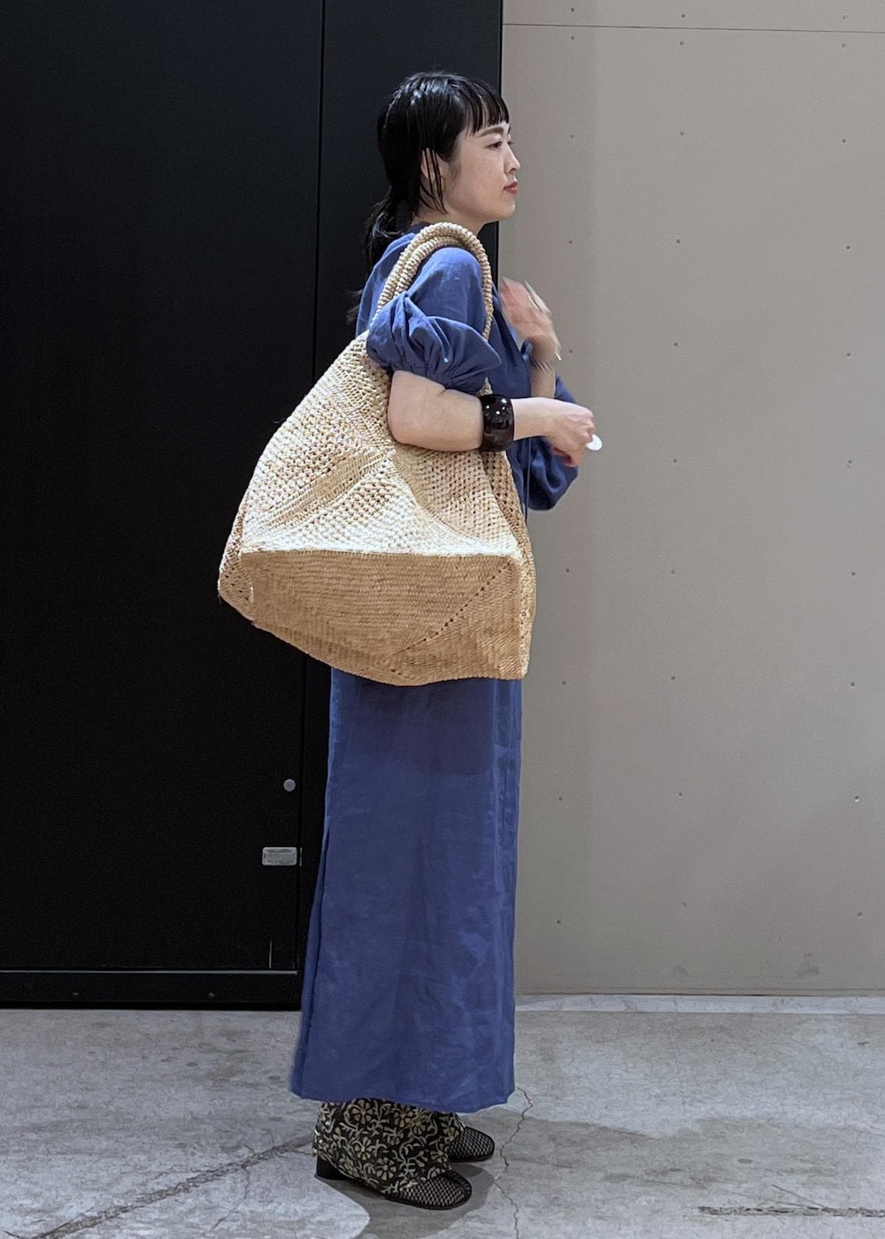 グレー系のその他パンツ、ホワイト系のかごバッグ、ブルー系のワンピースを着用したレディースの春コーディネートの4枚目の写真