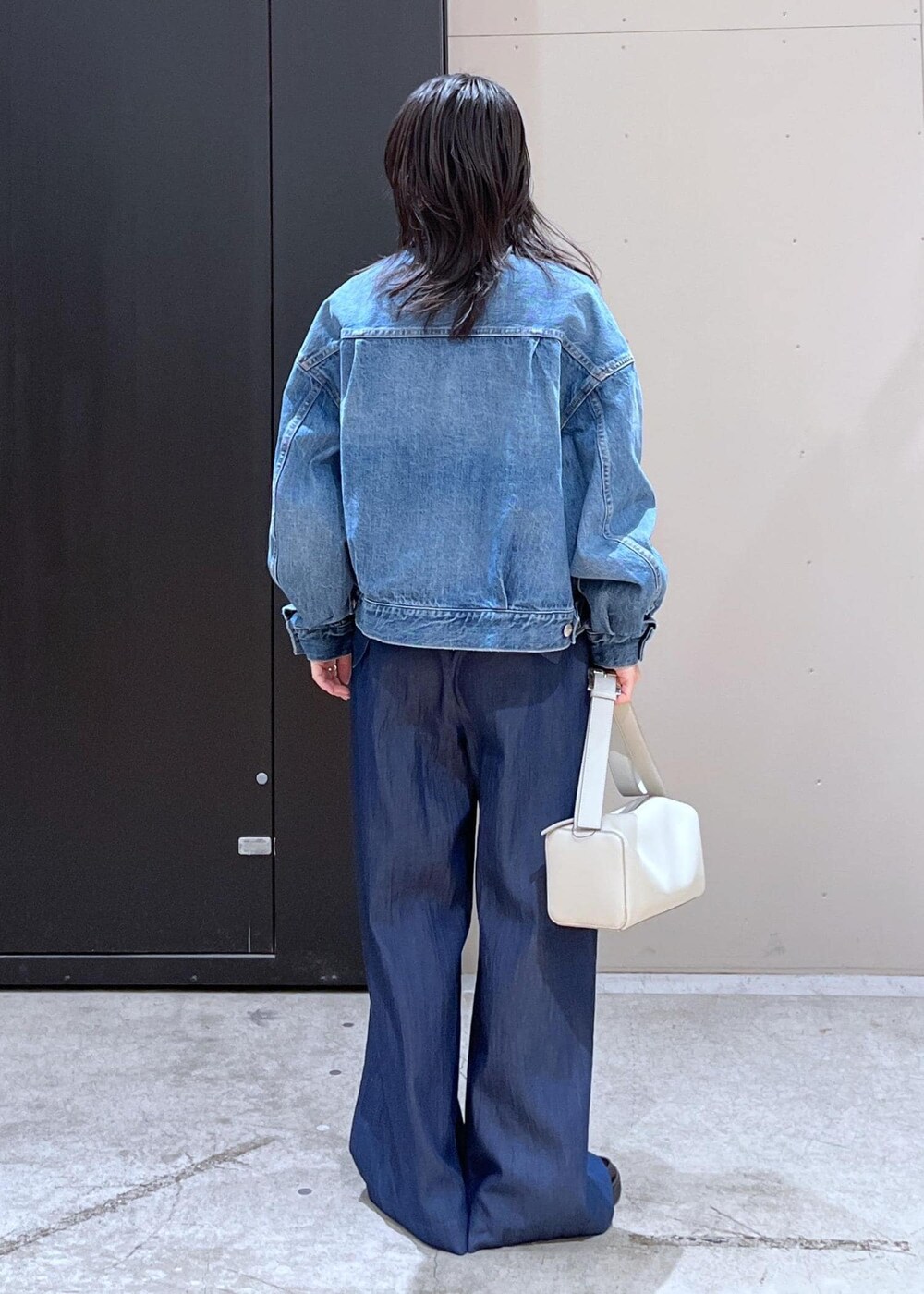 グレー系のショルダーバッグ、ブルー系のつなぎ/オールインワン、ブルー系のTシャツ/カットソーを着用したレディースの冬コーディネートの3枚目の写真
