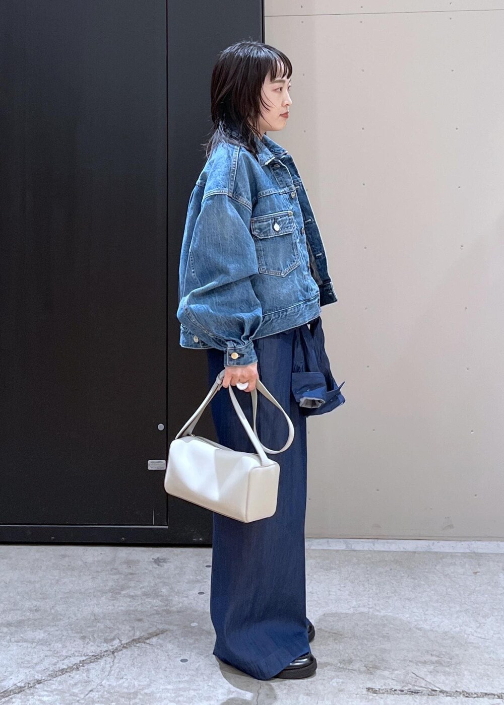 グレー系のショルダーバッグ、ブルー系のつなぎ/オールインワン、ブルー系のTシャツ/カットソーを着用したレディースの冬コーディネートの2枚目の写真
