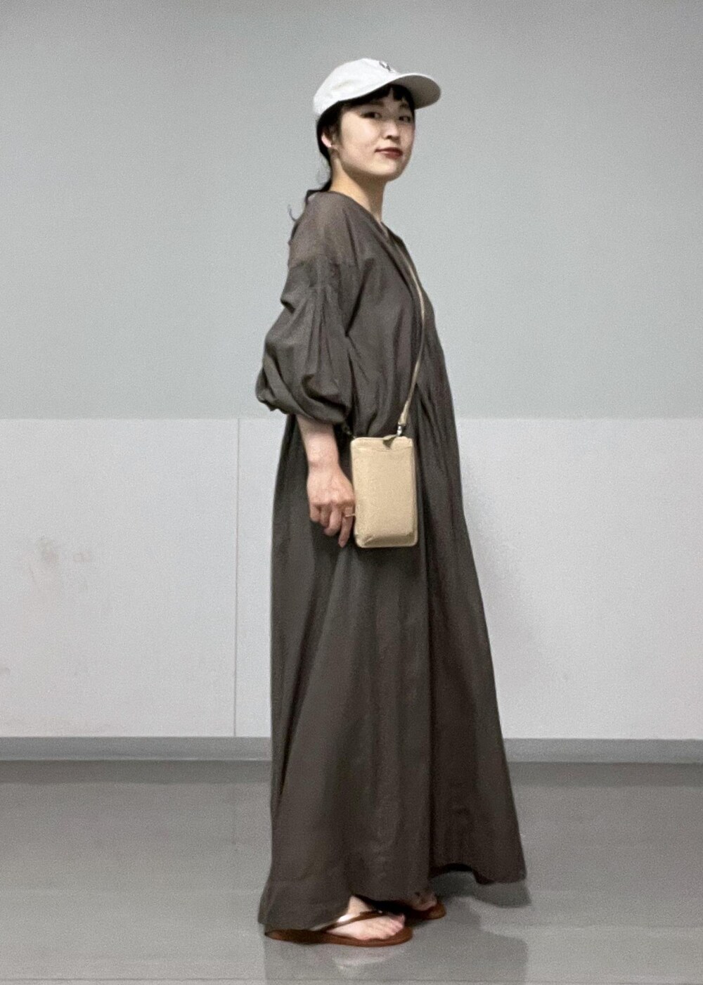 ブラウン系のサンダル、ベージュ系のショルダーバッグ、グレー系のワンピースを着用したレディースの夏コーディネートの4枚目の写真