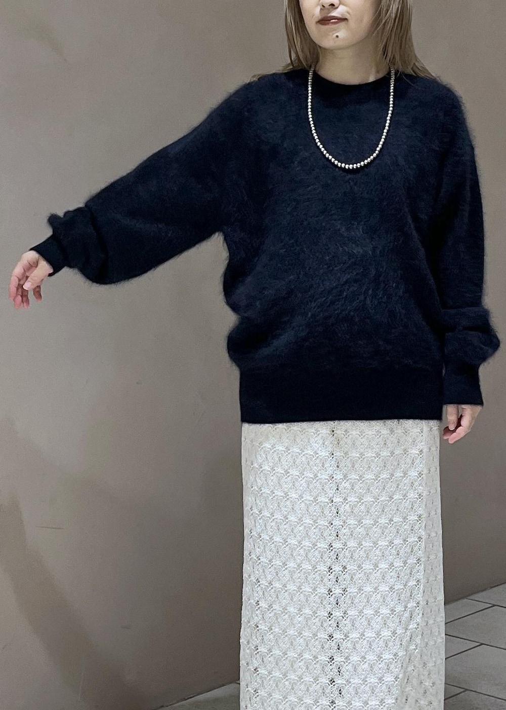 ホワイト系のスカート、ブルー系のニット/セーター、ホワイト系のスラックスを着用したレディースの秋コーディネートの7枚目の写真