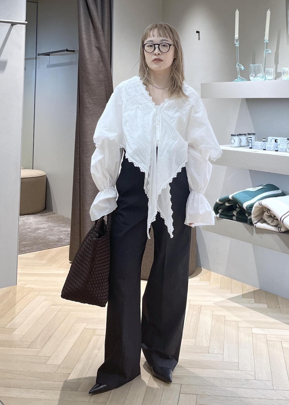 ブラック系のスラックス、ブラック系のパンプス、ホワイト系のシャツ/ブラウスを着用したレディースの冬コーディネートの2枚目の写真