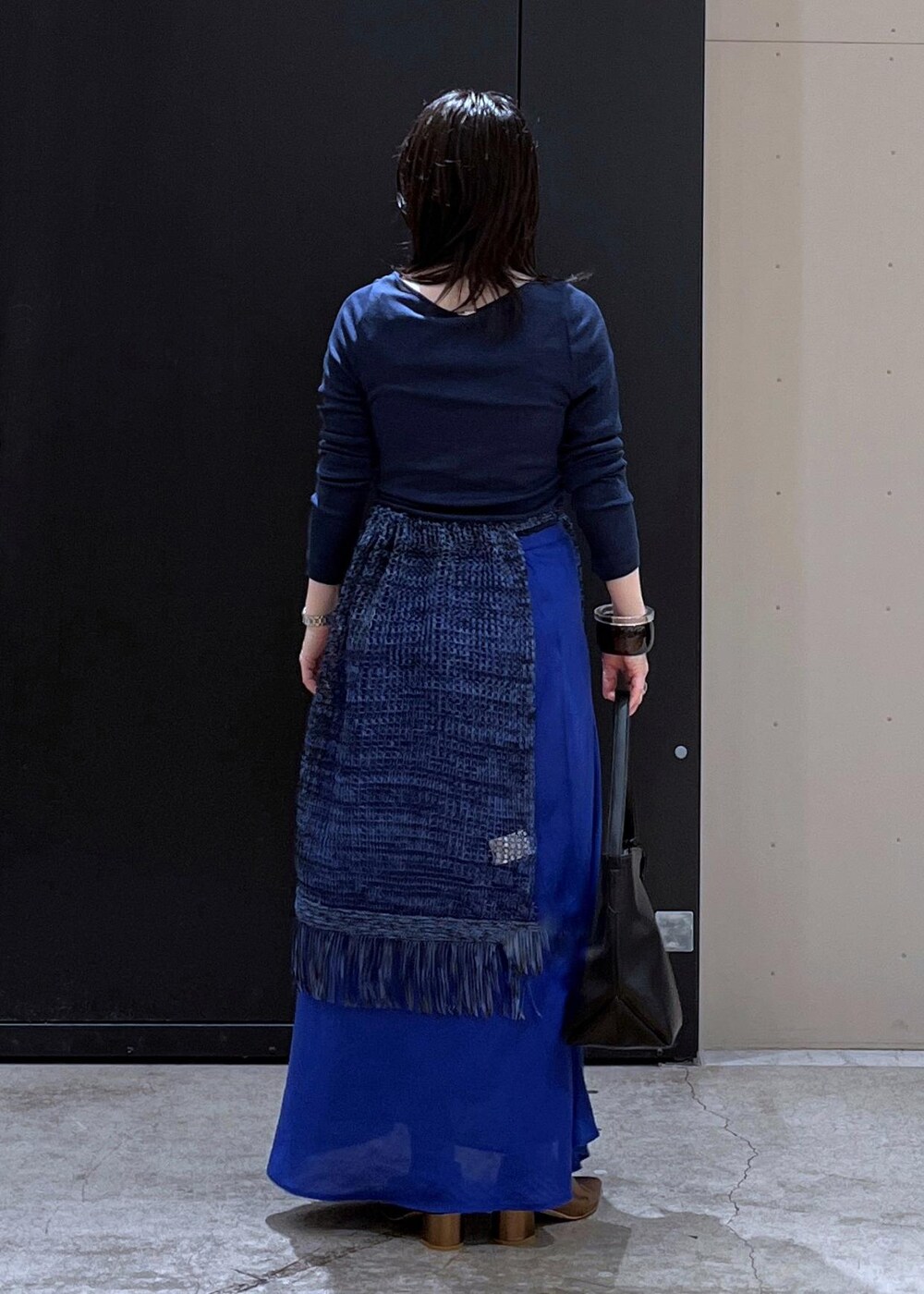 ブラック系のショルダーバッグ、その他のパンプス、ブルー系のスカートを着用したレディースの春コーディネートの3枚目の写真