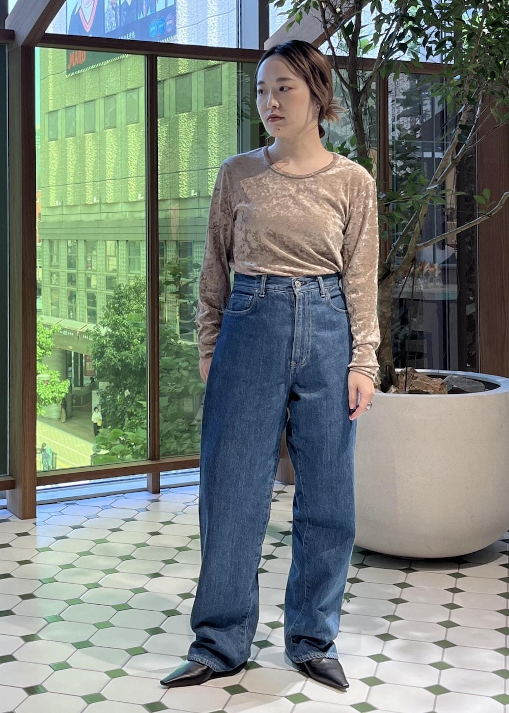 ベージュ系のショルダーバッグ、ブラック系のダウンジャケット/コート、ブルー系のデニムジャケットを着用したレディースの秋コーディネートの6枚目の写真