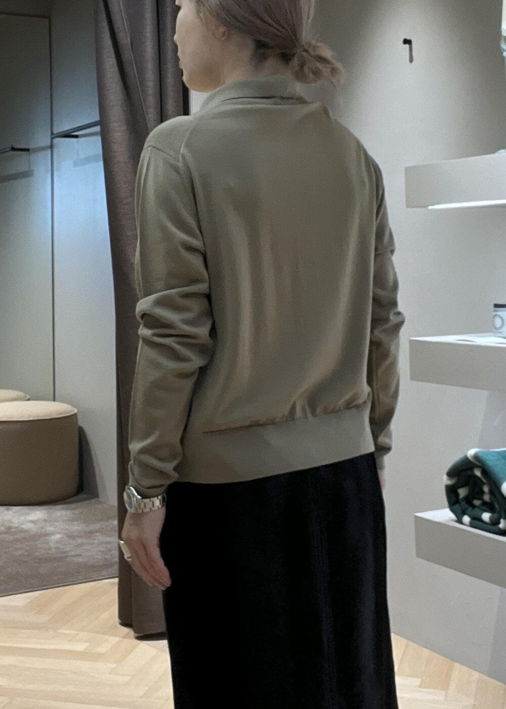 ブラック系のブーツ、ブラック系のスカート、ベージュ系のニット/セーターを着用したレディースの冬コーディネートの5枚目の写真