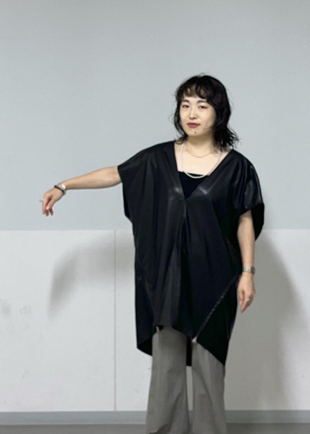 グレー系のスラックス、ブラック系のシャツ/ブラウス、ブラック系のチューブトップを着用したレディースの秋コーディネートの2枚目の写真