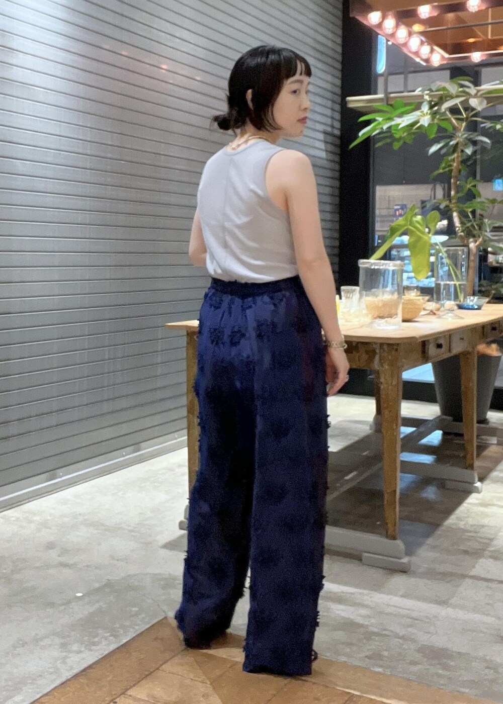 ブラック系のサンダル、ブラック系のショルダーバッグ、グレー系のタンクトップを着用したレディースの夏コーディネートの7枚目の写真