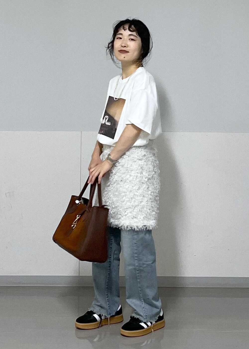 ホワイト系のTシャツ/カットソー、ホワイト系のスカート、ブラウン系のハンドバッグを着用したレディースの夏コーディネートの2枚目の写真