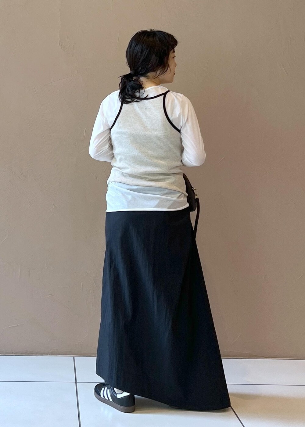 ブラック系のスカート、ベージュ系のタンクトップ、ホワイト系のTシャツ/カットソーを着用したレディースの夏コーディネートの5枚目の写真