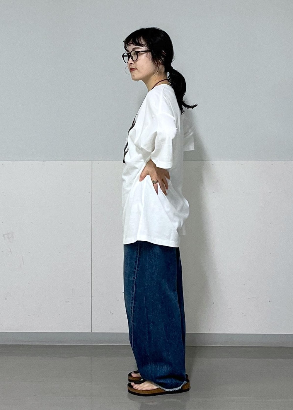 ブラック系のトートバッグ、ブルー系のデニムパンツ、ホワイト系のTシャツ/カットソーを着用したレディースの夏コーディネートの4枚目の写真