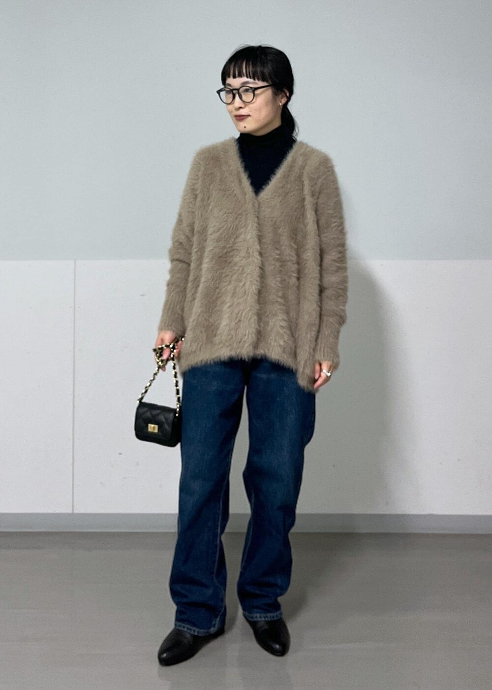 ブラック系のショルダーバッグ、ブラック系のブーツ、ブラック系のTシャツ/カットソーを着用したレディースの秋コーディネートの2枚目の写真