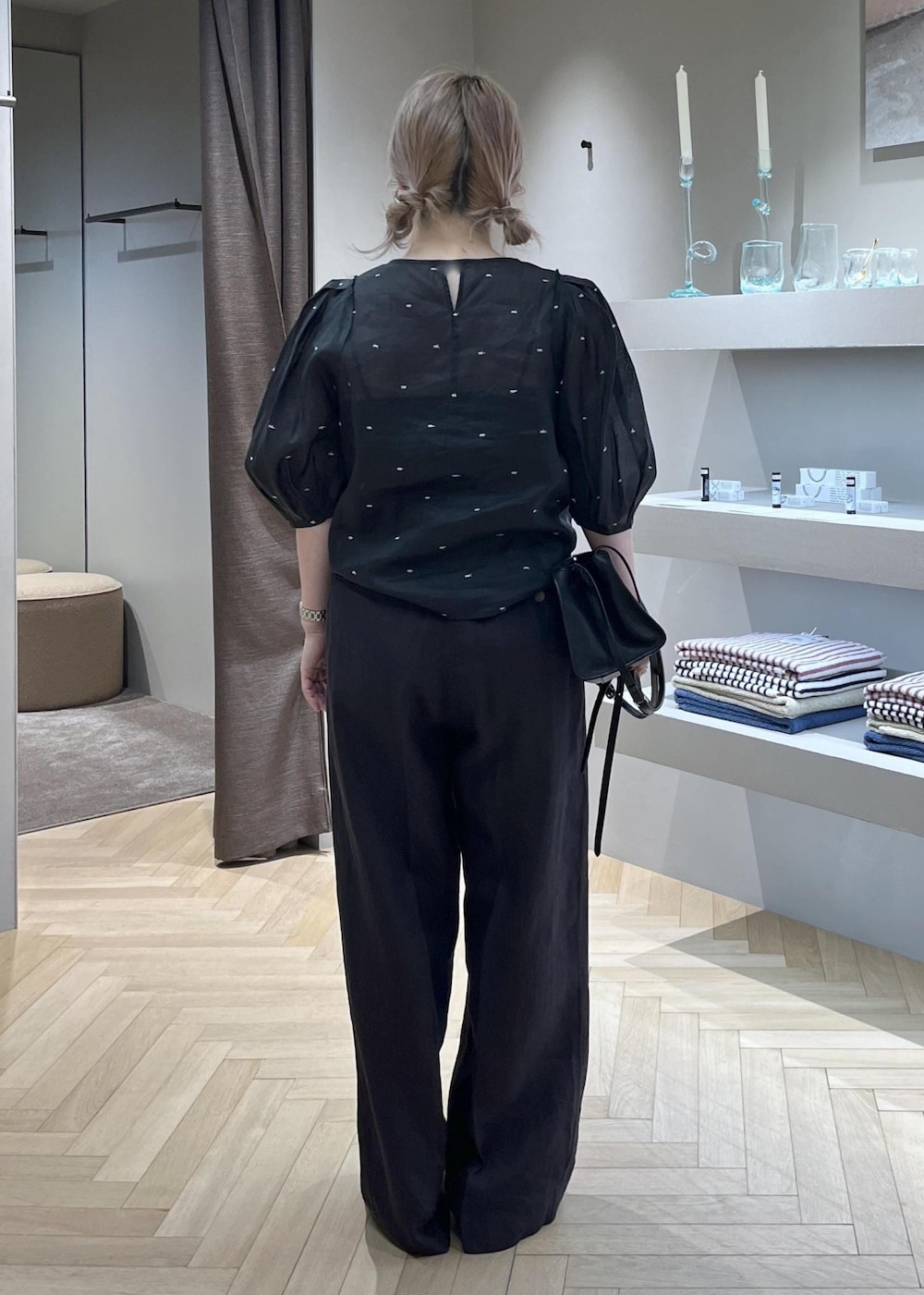 ブラック系のスラックス、ブラック系のキャミソール、ブラック系のハンドバッグを着用したレディースの春コーディネートの4枚目の写真