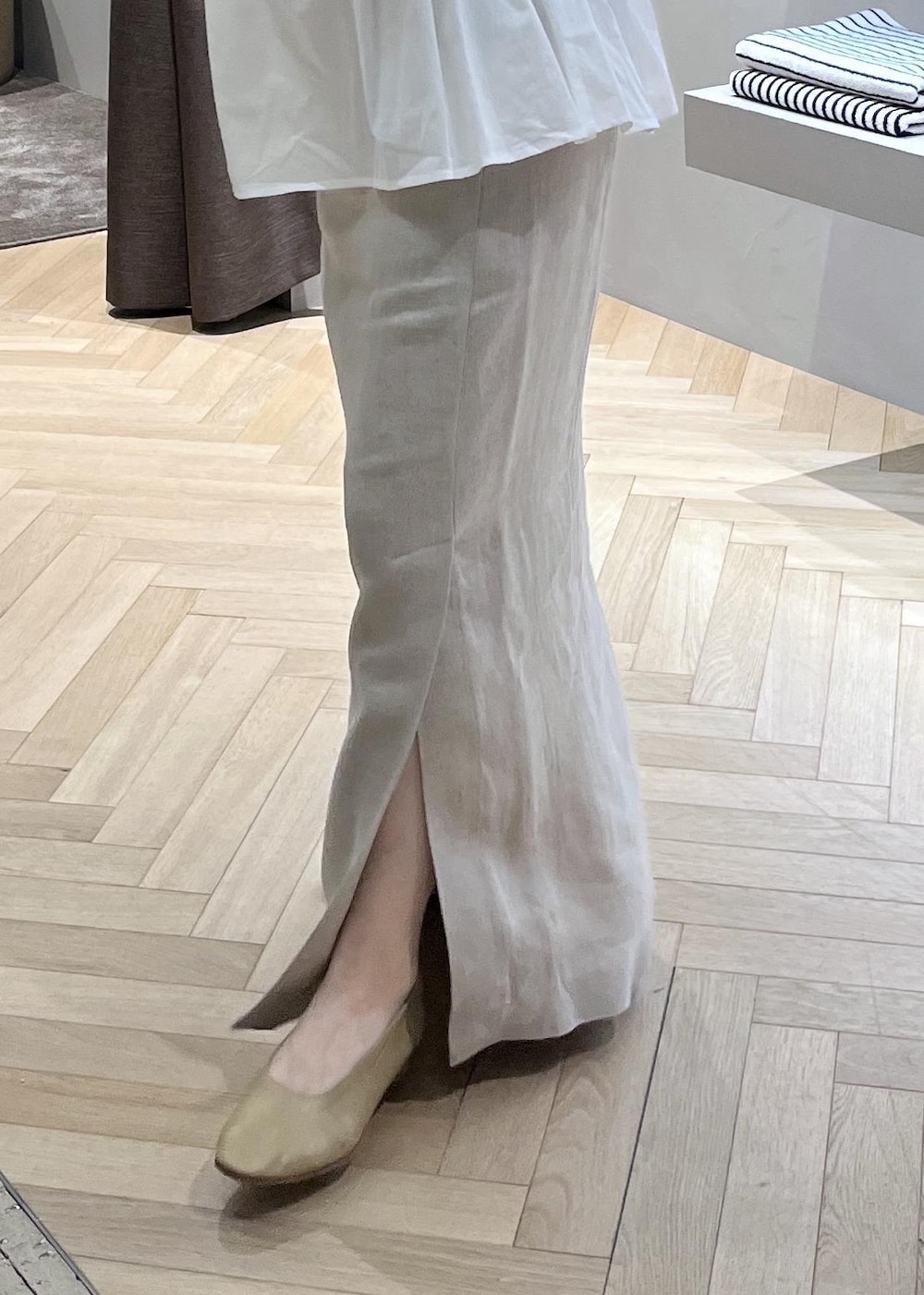 ベージュ系のスカート、ホワイト系のブルゾン、イエロー系のショルダーバッグを着用したレディースの春コーディネートの8枚目の写真