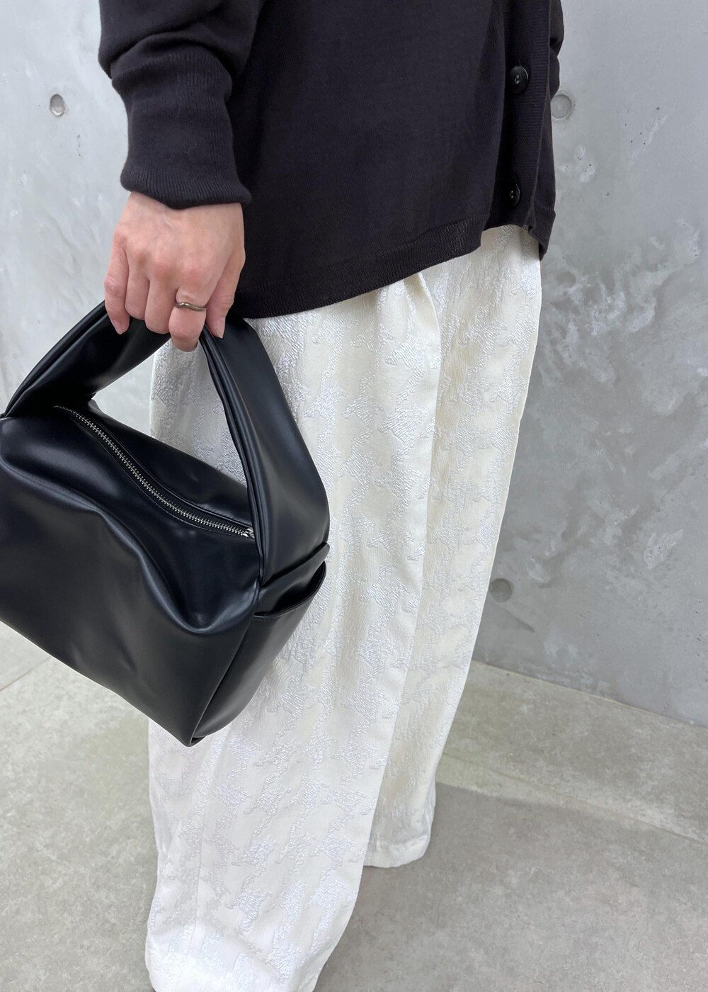 ブラック系のTシャツ/カットソー、ブラック系のハンドバッグ、ブラック系のブーツを着用したレディースの夏コーディネートの7枚目の写真