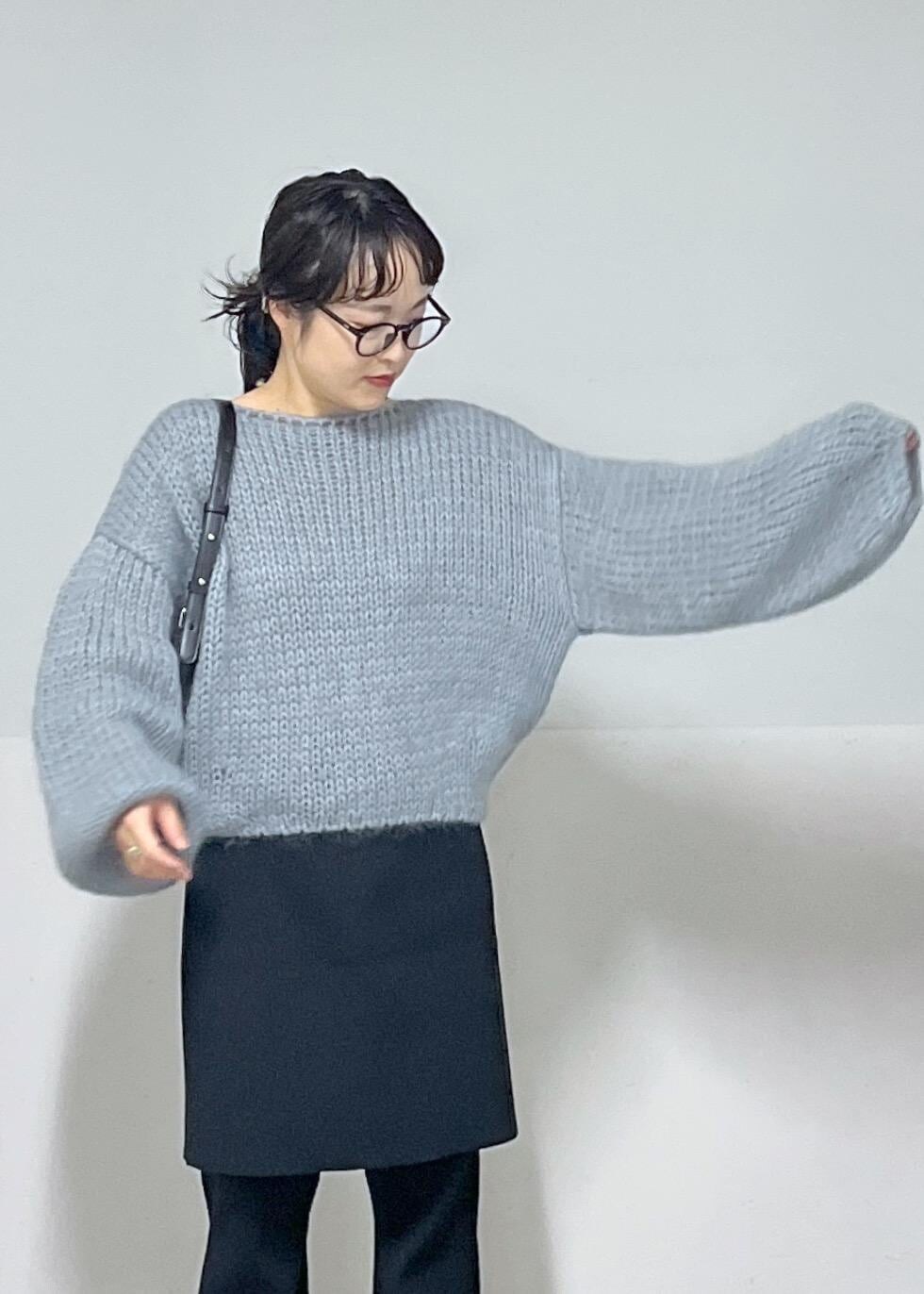 ブラック系のブーツ、ブラック系のスカート、ブルー系のニット/セーターを着用したレディースの秋コーディネートの5枚目の写真