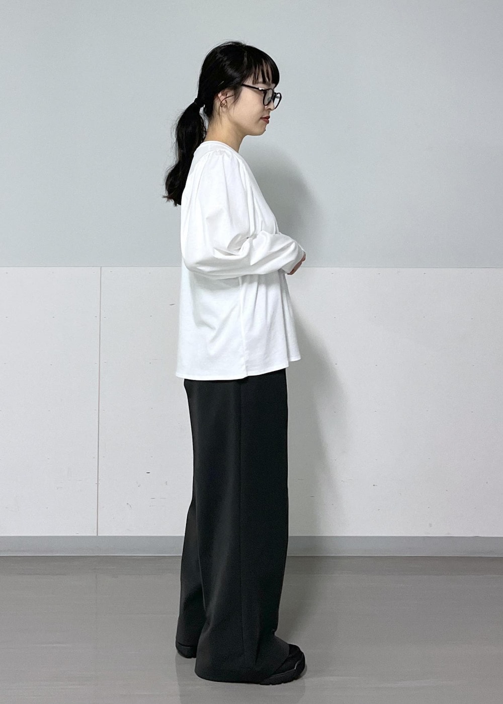 グレー系のその他パンツ、ブラック系のハンドバッグ、ホワイト系のTシャツ/カットソーを着用したレディースの秋コーディネートの8枚目の写真