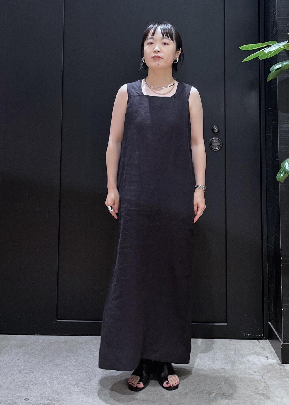 ブラック系のサンダル、ベージュ系のシャツ/ブラウス、ブラック系のジャンパースカートを着用したレディースの夏コーディネートの6枚目の写真