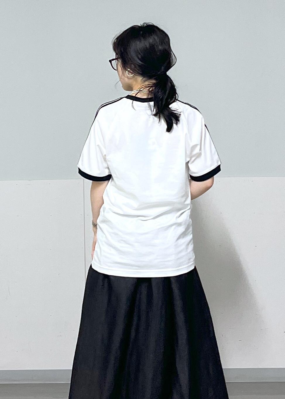 ブラック系のスカート、ゴールド系のサンダル、シルバー系のハンドバッグを着用したレディースの夏コーディネートの6枚目の写真