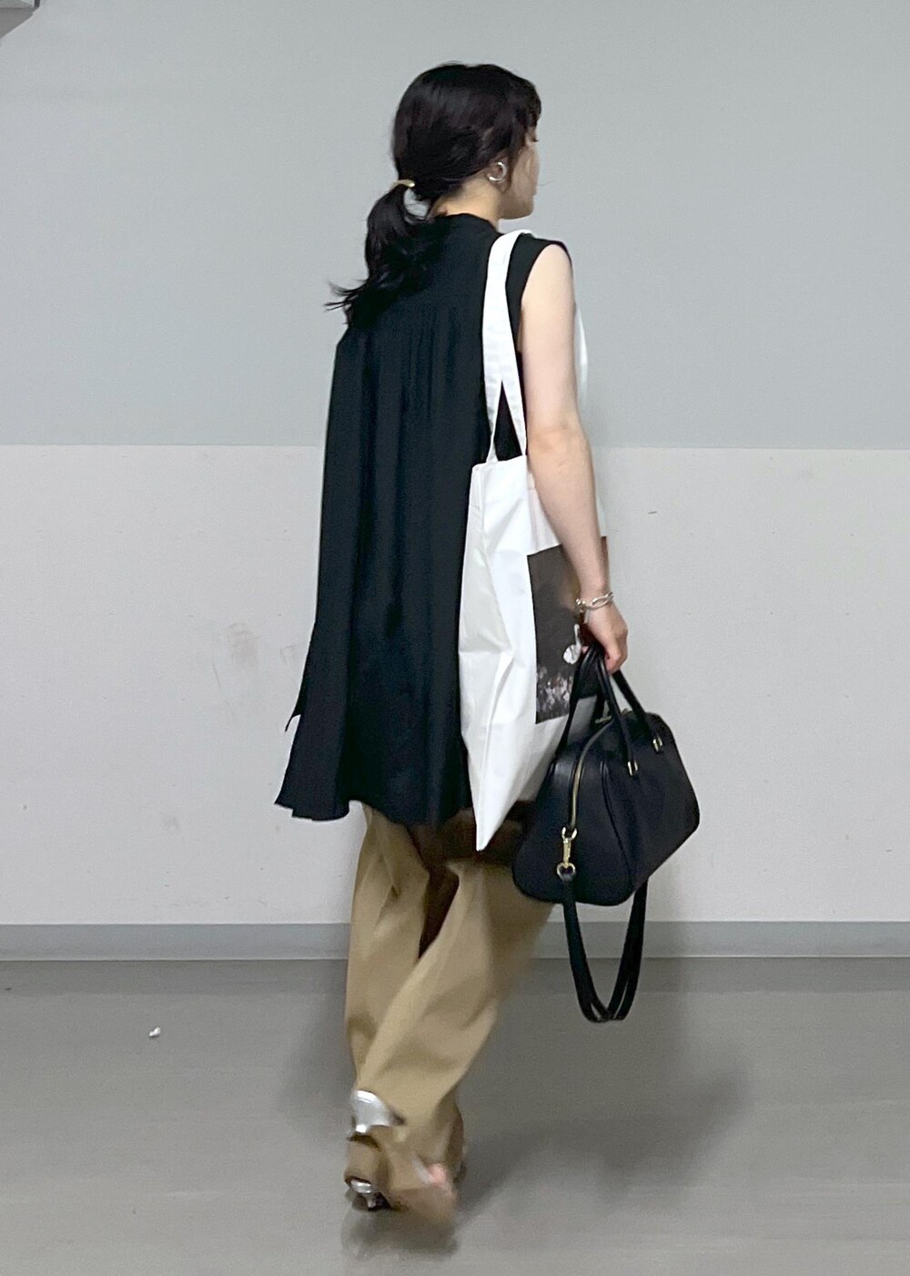 ベージュ系のその他パンツ、シルバー系のサンダル、ホワイト系のトートバッグを着用したレディースの夏コーディネートの3枚目の写真